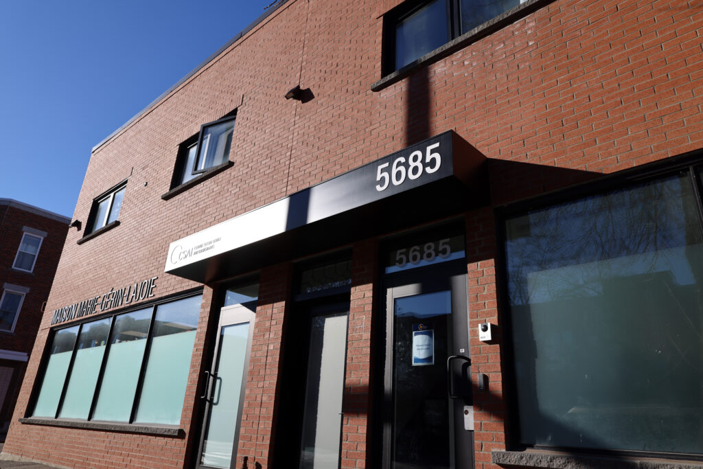 Façade de *La Maison Marie-Gérin-Lajoie* au 5685 rue Laurendeau, un bâtiment en brique rouge abritant le centre d’hébergement temporaire du CSAI pour les réfugiés pris en charge par l’État (RPCÉ). L’entrée principale affiche le logo du CSAI et le numéro civique du bâtiment.